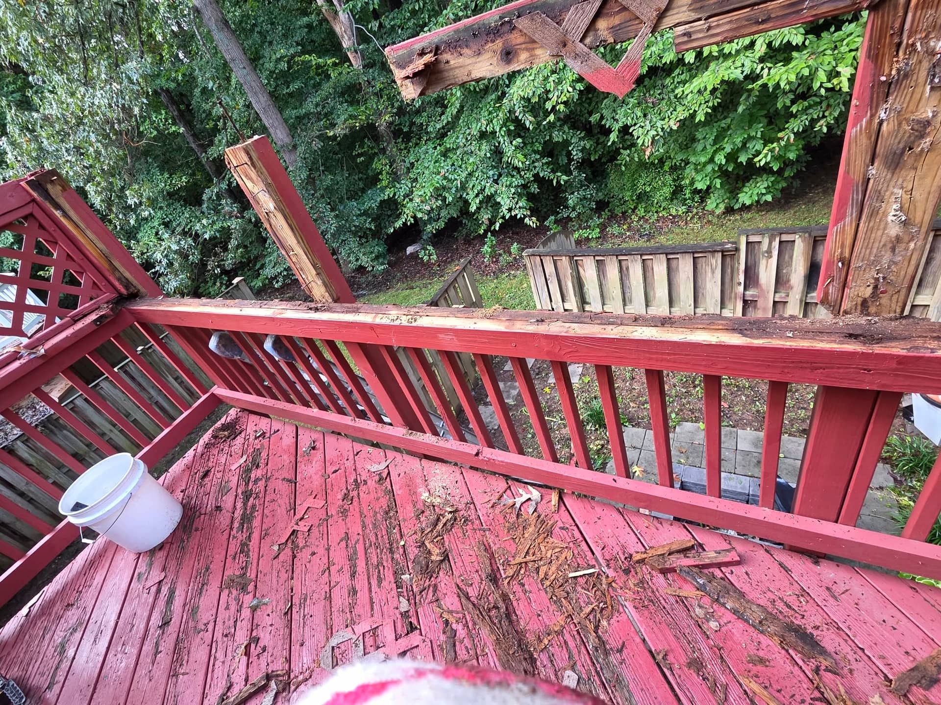 Damaged upper railing sections being removed from the existing wood deck.